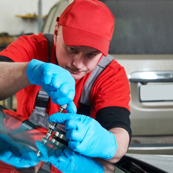Techniker bringt Reparaturharz in einen Steinschlag ein